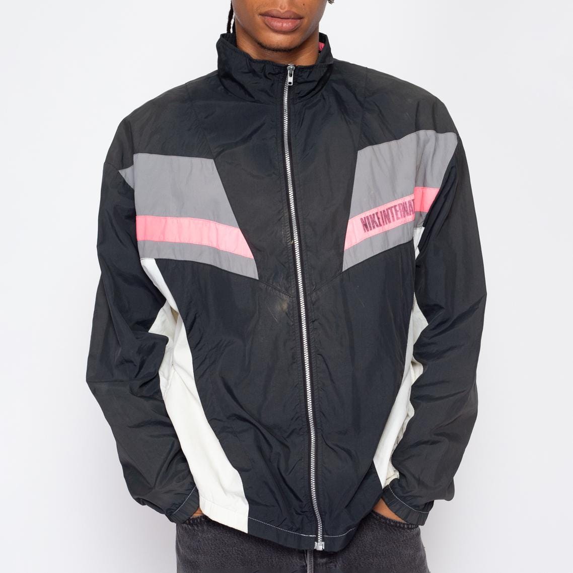 Chaqueta deportiva Nike International de los anos 90 con logo Swoosh y diseno desgastado estilo vintage con rompevientos y bloques de color descolorido Etsy Mexico