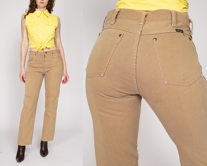 May include: A pair of light brown high-waisted jeans with a straight leg fit. The jeans have a classic five-pocket design and a button fly.