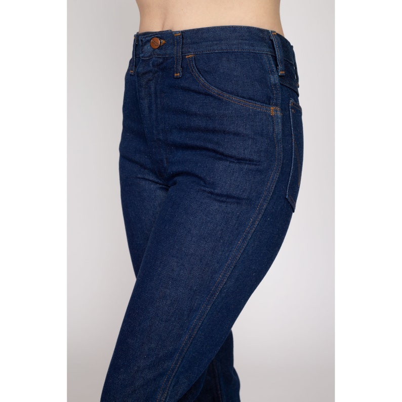 K&ouml;nnte beinhalten: Dunkelblaue Jeans aus Denim mit hohem Bund und klassischem F&uuml;nf-Taschen-Design. Die Jeans haben einen Knopfverschluss und einen geraden Beinverlauf. Die N&auml;hte sind in einer kontrastierenden Beiget&ouml;nung gehalten.