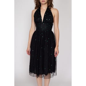 May include: A black halter dress with a green sequin pattern. The dress has a fitted bodice and a full skirt.