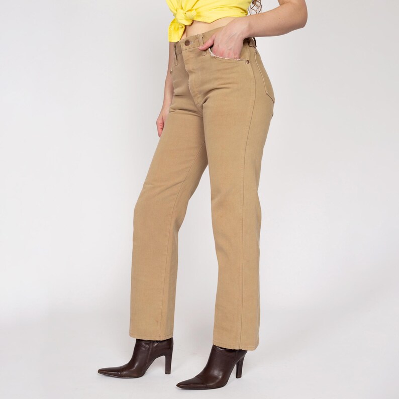 May include: A pair of light brown, straight-leg jeans with a high waist.
