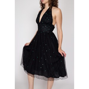 May include: A black tulle dress with a halter neckline and green polka dots. The dress has a fitted bodice and a full skirt.