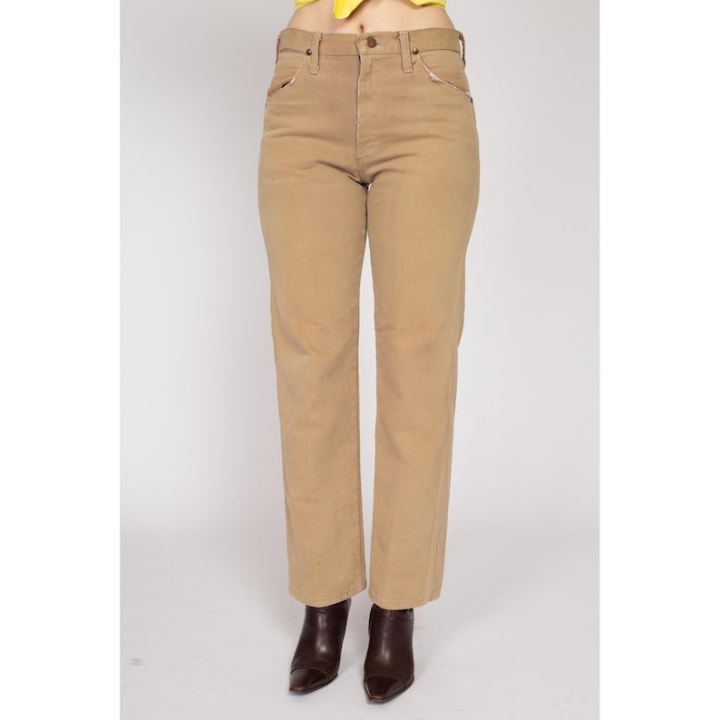 May include: A pair of light brown straight-leg jeans with a high waist.
