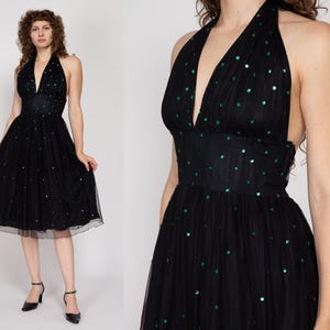 May include: A black halter dress with a green sequin pattern. The dress has a fitted bodice and a full skirt.