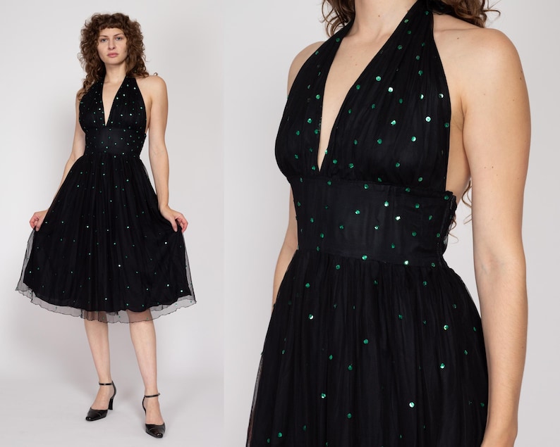 May include: A black halter dress with a green sequin pattern. The dress has a fitted bodice and a full skirt.