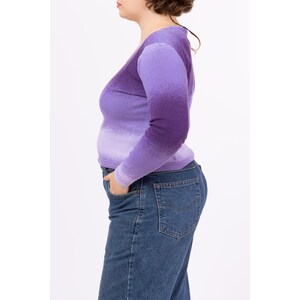 May include: A purple ombre long-sleeve shirt with a V-neckline.