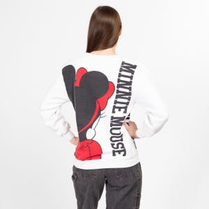 May include: White sweatshirt with a black and red Minnie Mouse graphic on the back. The text "MINNIE MOUSE" is printed vertically on the right side of the graphic.