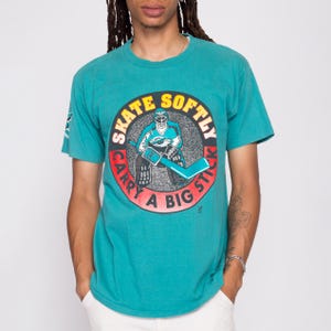 Camiseta de hockey sobre hielo para hombre de la Liga Internacional IHL de los años 90 con la frase "Patina suavemente, lleva un palo grande" de Las Vegas Thunder. Camiseta gráfica vintage de la Liga Internacional IHL.
