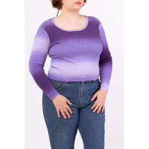May include: A long-sleeved, purple ombre shirt with a scoop neck. The shirt is made of a soft, stretchy fabric and has a relaxed fit.