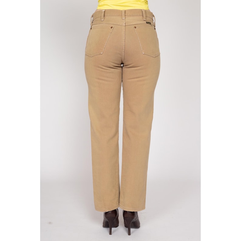 May include: A pair of tan straight-leg jeans with a high waist and a classic fit.