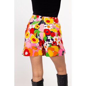 May include: A pair of pink, orange, yellow, red, and green floral print shorts. The shorts have a high waist and a wide leg.