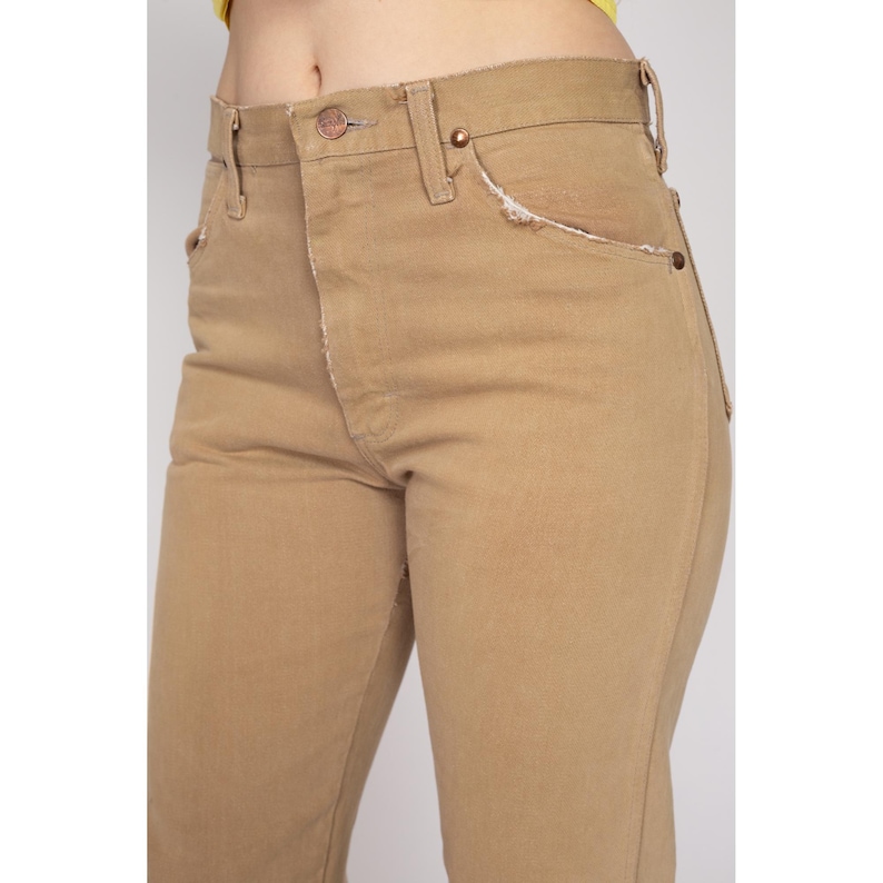 May include: A pair of light brown high-waisted jeans with a straight leg fit.