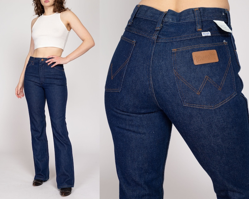 K&ouml;nnte beinhalten: Dunkelblaue Wrangler Jeans aus Denim. Die Jeans haben eine hohe Taille und ein ausgestelltes Bein. Die Ges&auml;&szlig;tasche hat einen braunen Lederaufn&auml;her mit dem Wrangler-Logo. Die Jeans sind ein klassischer Stil.