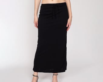 May include: A black maxi skirt with a drawstring waist and a side slit. The skirt is made of a soft, stretchy fabric.