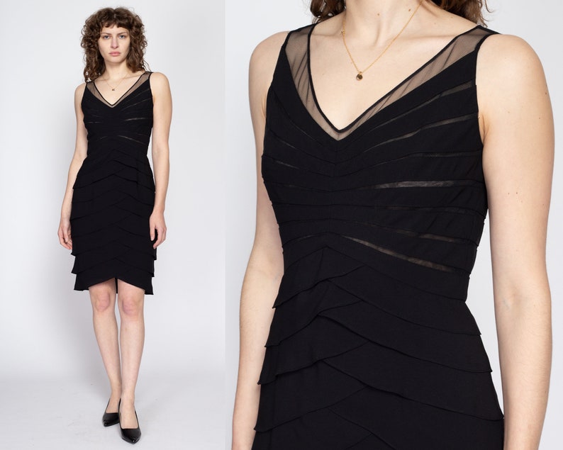 May include: A black sleeveless dress with a layered skirt and a sheer mesh panel at the neckline.