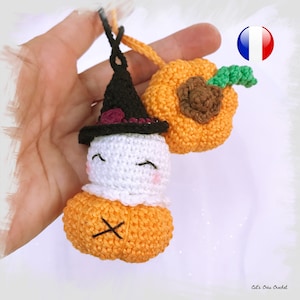 Peut inclure: Deux décorations d'Halloween en crochet, l'une est une citrouille avec une tige verte et l'autre est un fantôme portant un chapeau de sorcière noir avec une fleur violette.