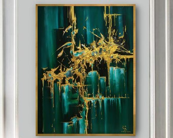 May include: A white couch with black and white patterned pillows in a living room setting. A gold framed abstract painting with green and gold colors hangs on the wall above the couch. A glass coffee table with a gold ice bucket and champagne glasses sits in front of the couch.