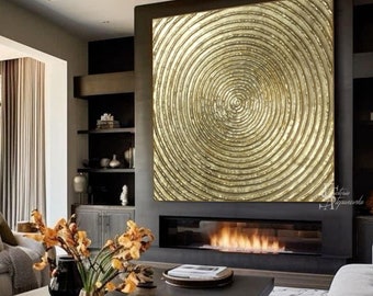 May include: A modern living room with a large gold abstract painting above a fireplace. The room is decorated in a neutral color palette with gray furniture and a black coffee table. There are flowers in a vase on the coffee table.