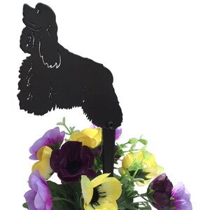 Peut inclure: Silhouette noire en métal d'un cocker spaniel, debout, la tête levée. La silhouette est fixée à un piquet en métal et placée dans un pot de fleurs avec des fleurs violettes, jaunes et blanches.