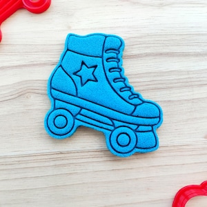 May include: Blue roller skate cookie cutter with a star on the side. The cutter is made of plastic and is designed to cut out cookies in the shape of a roller skate.