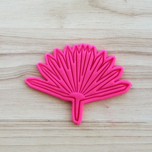 Puede incluir: Cortador de galletas de silicona rosa en forma de hoja de palmera de abanico.