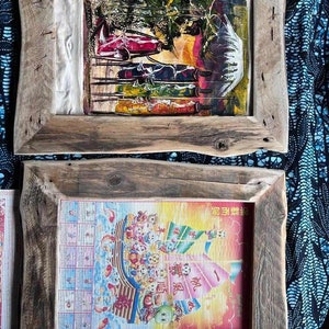 May include: Two wooden frames with different images inside. The top frame has a colorful abstract painting with a white background. The bottom frame has a colorful image of a boat with Chinese characters.