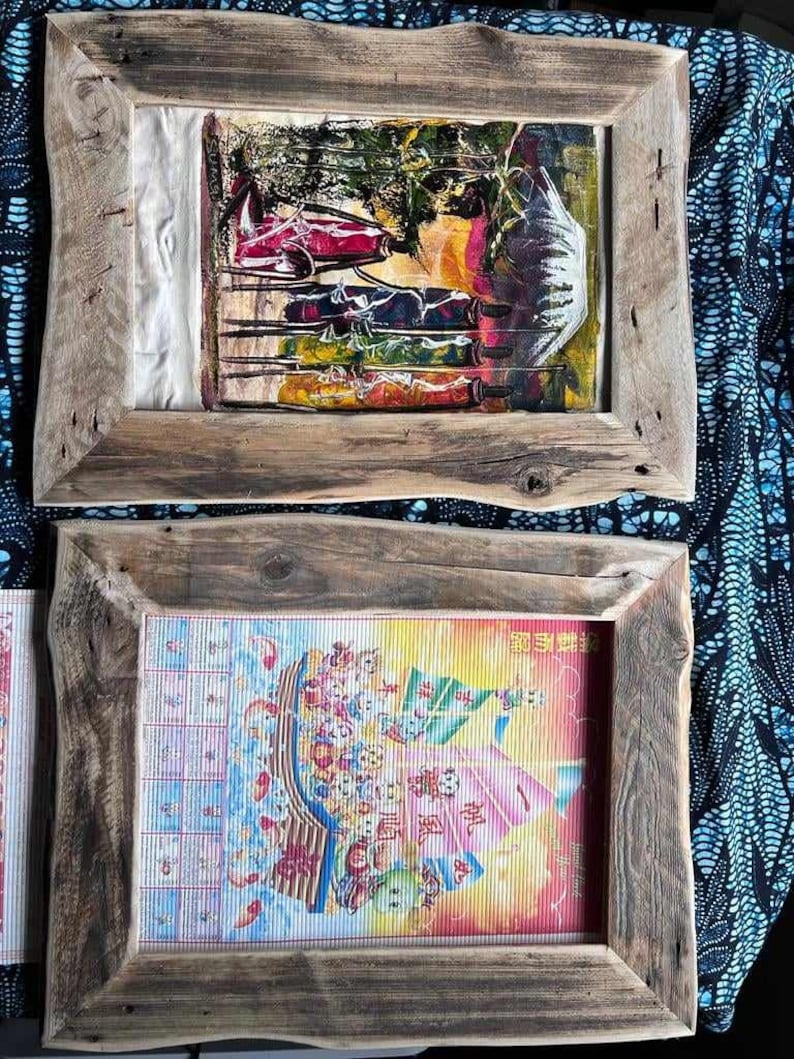 May include: Two wooden frames with different images inside. The top frame has a colorful abstract painting with a white background. The bottom frame has a colorful image of a boat with Chinese characters.