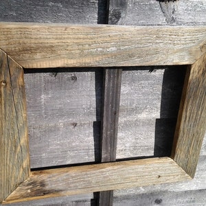 May include: A rustic wooden picture frame with a weathered, natural finish. The frame is made of reclaimed wood and has a simple, rectangular shape.