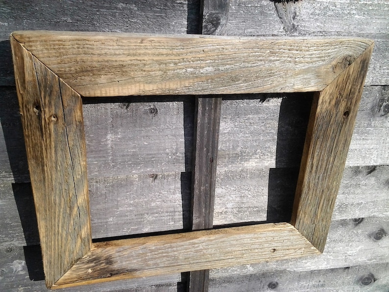 May include: A rustic wooden picture frame with a weathered, natural finish. The frame is made of reclaimed wood and has a simple, rectangular shape.