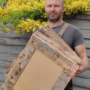 May include: A stack of rustic wooden picture frames with a natural wood finish. The frames are made from reclaimed wood and have a unique, weathered look.