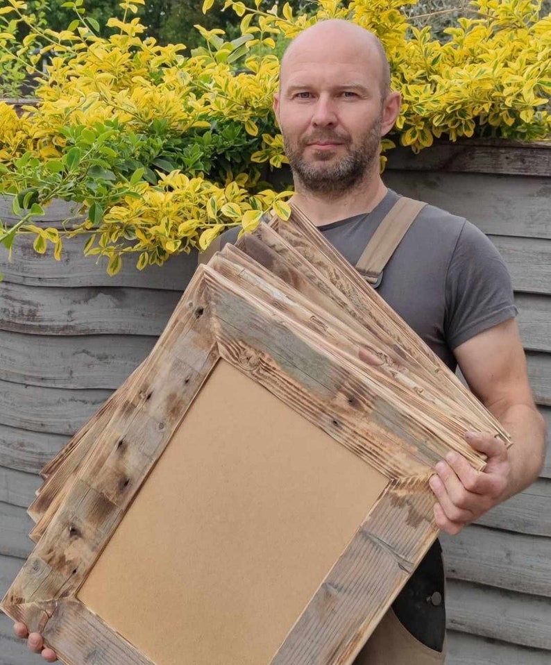 May include: A stack of rustic wooden picture frames with a natural wood finish. The frames are made from reclaimed wood and have a unique, weathered look.