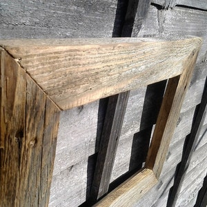 May include: A rustic wooden picture frame with a natural wood finish. The frame is made of reclaimed wood and has a distressed look. The frame is perfect for adding a touch of rustic charm to any home.
