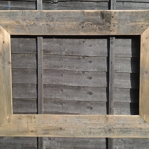 May include: A rustic wooden picture frame with a natural wood finish. The frame is made of reclaimed wood and has a distressed look.