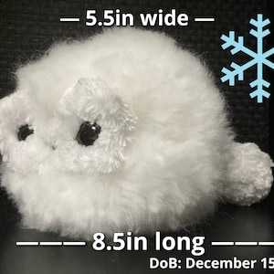 May include: A white fluffy plush toy shaped like a small animal with black eyes. The toy is 5 inches tall, 5.5 inches wide, and 8.5 inches long. The toy is labeled with a date of December 15, 2022.