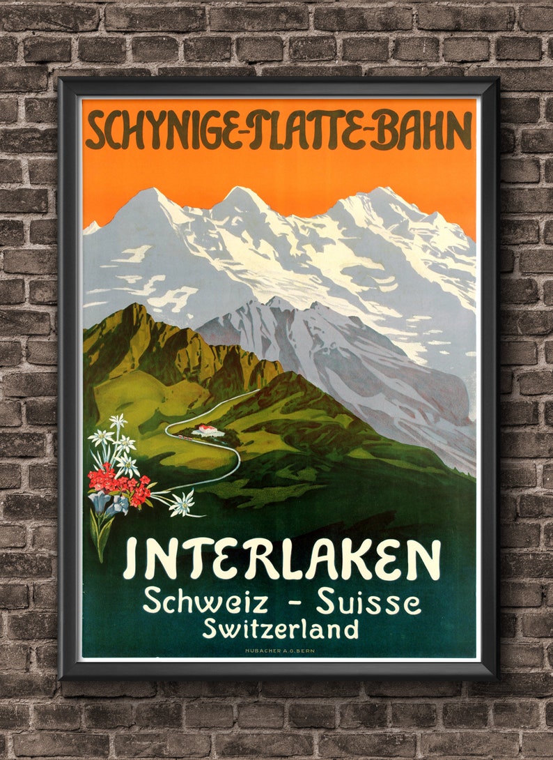 May include: Vintage travel poster advertising the Schynige Platte Bahn in Interlaken, Switzerland. The poster features a scenic mountain landscape with snow-capped peaks and a winding road leading up to a small village. The text on the poster reads "Schynige Platte Bahn" and "Interlaken, Schweiz - Suisse, Switzerland".