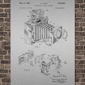 May include: A black and white line drawing of a photographic camera accessory patent. The patent is titled "Photographic Camera Accessory" and was filed on December 18, 1963, by Herbert A. Bing. The patent number is 3,253,528. The drawing shows a detailed view of the camera accessory.
