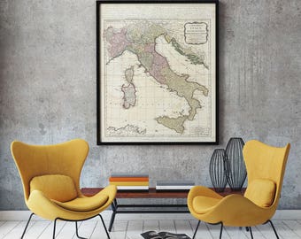 May include: Two yellow armchairs with black metal frames face each other in a living room. A coffee table with a black metal frame and a wooden top sits between the chairs. A framed map of Italy hangs on the wall behind the chairs.