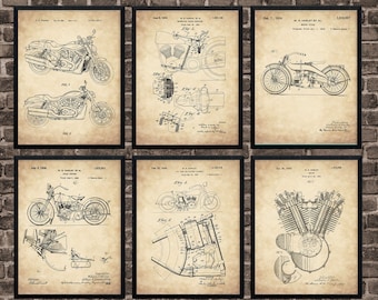 May include: Six framed vintage motorcycle patent prints. Each print features detailed technical drawings of different motorcycle designs and components, with dates and patent information. The prints are in black frames against a brick wall background.