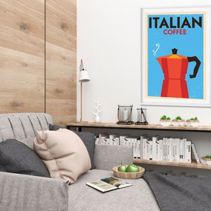 Może przedstawiać: Wnętrze salonu z szarą sofą, drewnianą p&oacute;łką z książkami i oprawionym plakatem z napisem "ITALIAN COFFEE" z czerwoną i czarną ilustracją dzbanka do kawy.