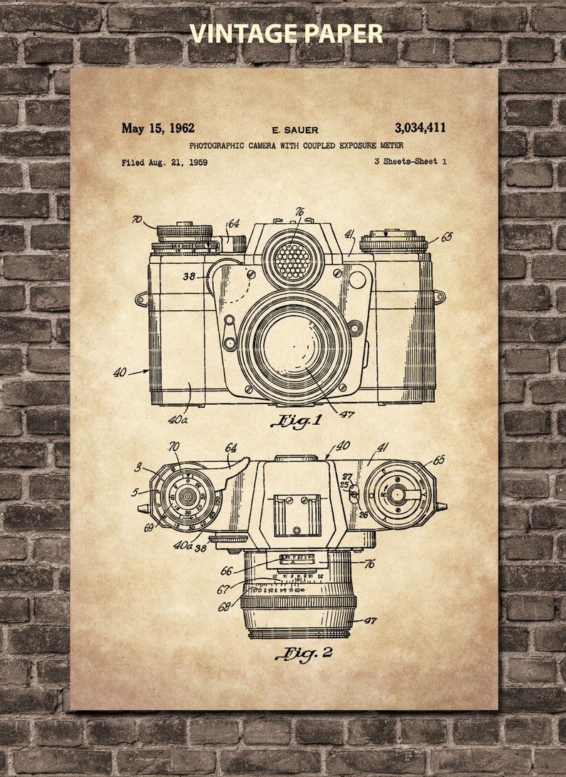 May include: A black and white line drawing of a photographic camera with coupled exposure meter. The drawing is from a patent filed on August 21, 1959, and granted on May 15, 1962. The patent number is 3,034,411. The drawing shows two views of the camera, one from the top and one from the side. The drawing is labeled "Fig. 1" and "Fig. 2".