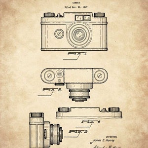 Op de afbeelding: Een zwart-witte lijntekening van een camerapatent. Het patent is voor een camera ontworpen door J.E. Harvey en ingediend op 21 november 1947. Het patentnummer is Des. 150,228. De tekening toont drie verschillende aanzichten van de camera.