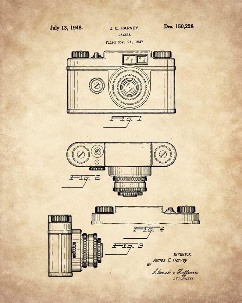 Op de afbeelding: Een zwart-witte lijntekening van een camerapatent. Het patent is voor een camera ontworpen door J.E. Harvey en ingediend op 21 november 1947. Het patentnummer is Des. 150,228. De tekening toont drie verschillende aanzichten van de camera.