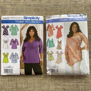 May include: Two Simplicity sewing pattern envelopes from the Khaliah Ali Collection. The left envelope is purple and white, featuring a woman in a purple top. The right envelope is pink and white, with a woman in a patterned top. Both feature various garment designs.