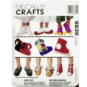 May include: McCall's Crafts pattern featuring various novelty slipper designs for children. The image showcases several pairs of slippers, including red boots, green shoes, and blue and tan booties. The text reads "Fancy Feet" and "Des Pieds Mignons".