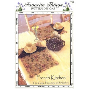 May include: A sewing pattern titled Favorite Things Pattern Designs 058 French Kitchen Tea Cozy, Placemats and Napkins. The cover features a table setting with a dark purple floral tea cozy, matching placemats, and napkins with scalloped edges.
