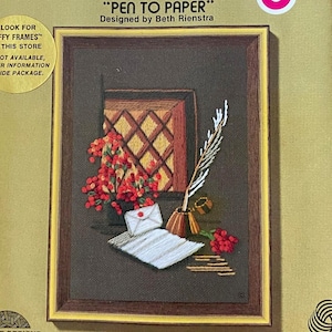 May include: A needlepoint kit titled Pen to Paper designed by Beth Rienstra. The embroidery depicts a brown background with a lattice-patterned window, a white envelope, a white letter, a quill pen in a stand, and clusters of red berries.