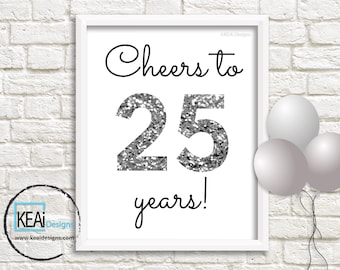 May include: A white framed printable sign with black text that reads "Cheers to 25 years!" The number 25 is in large silver glitter font. The sign is on a white brick wall with three silver balloons.