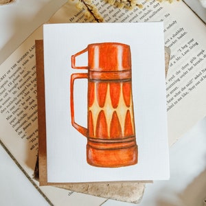 May include: A hand-drawn illustration of a vintage orange and yellow thermos with a lid and handle. The thermos has a retro design with a geometric pattern.