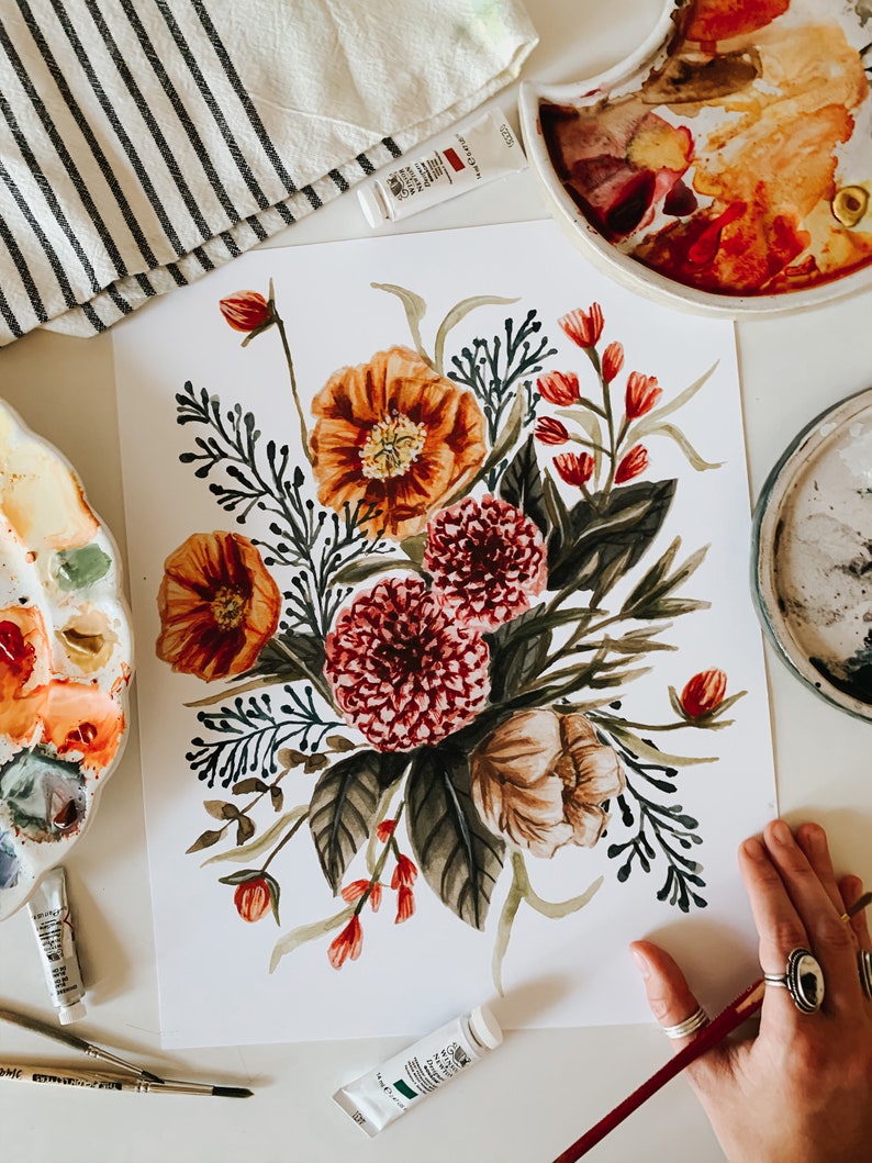 May include: Watercolour painting of a floral bouquet featuring red, orange and pink flowers. The flowers are surrounded by green leaves and stems. The painting is on a white background.