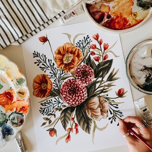 May include: A watercolour painting of a floral bouquet featuring orange, red, and pink flowers. The painting is on a white background and is being worked on by an artist.